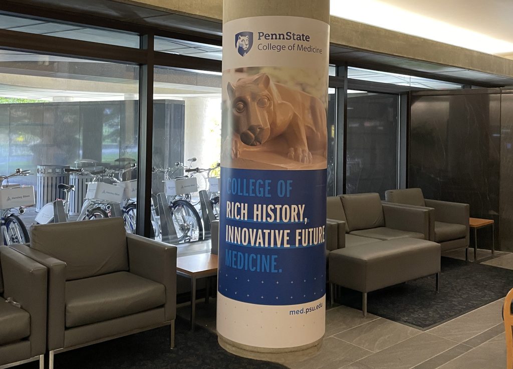 A column inside the College of Medicine is wrapped with a banner that says College of Rich History, Innovative Future Medicine